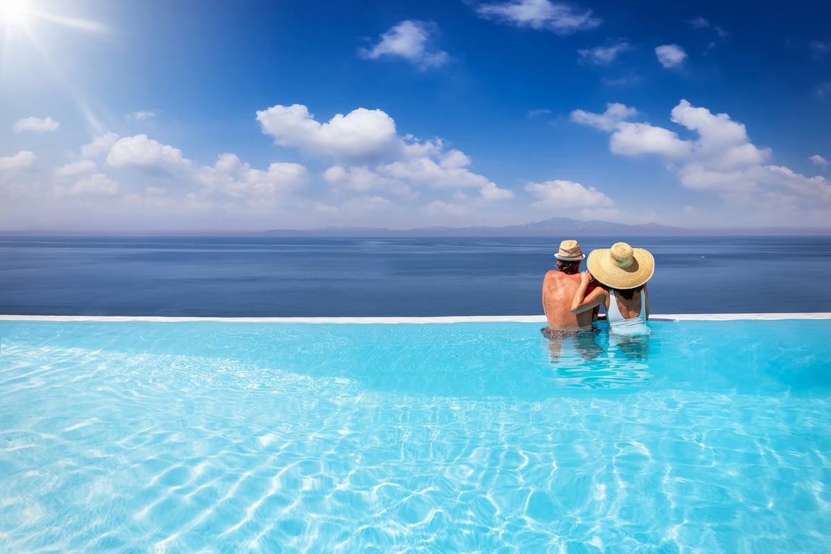 Pareja disfrutando junto a la piscina en vacaciones