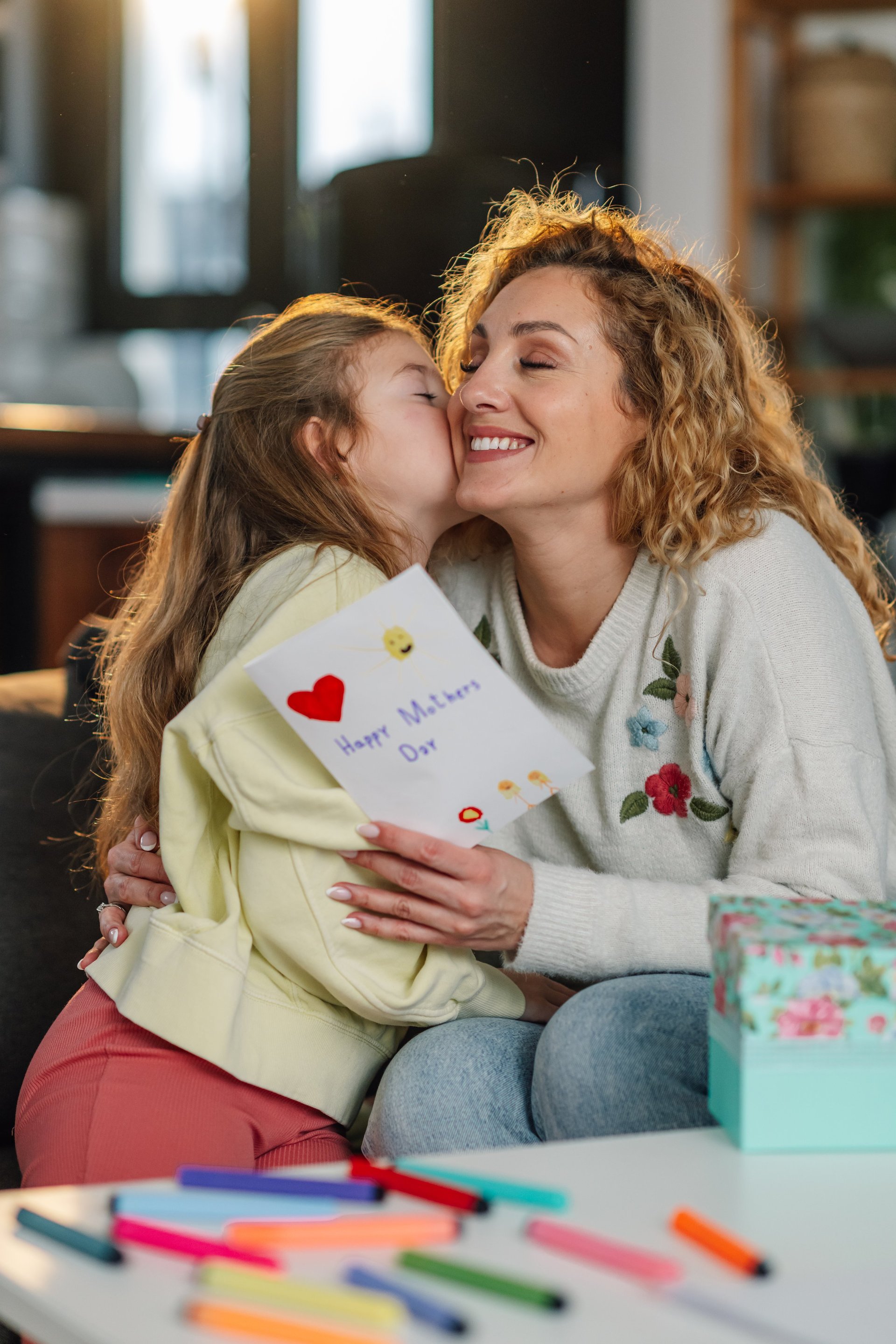 Hija abrazando y besando a su madre con cariño en el Día de la Madre