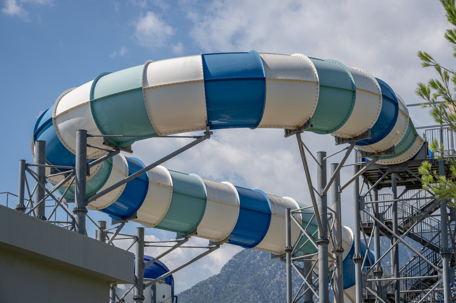 Giant blue and white tube waterslide in a luxury resort waterpark under blue sky