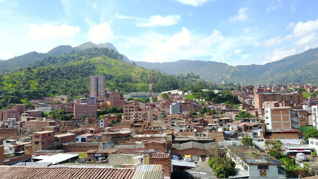 Paisaje urbano de Copacabana con densas edificaciones en ladrillo y montañas verdes al fondo bajo cielo azul